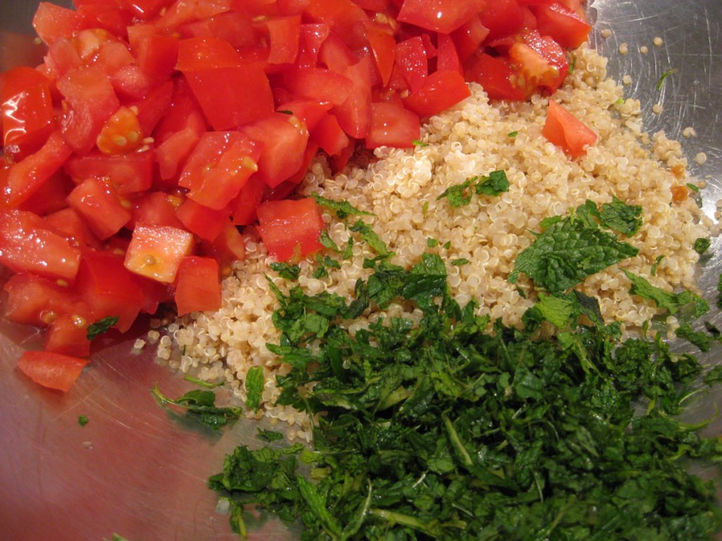 The start of making tabouli - the chopped tomato, cooked quinoa and chopped mint.